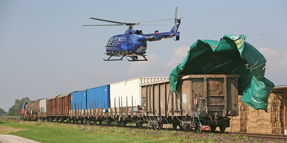 Helikopter im Flug über einem Zug während den Dreharbeiten zum SBB-Film «Der Experte 4»